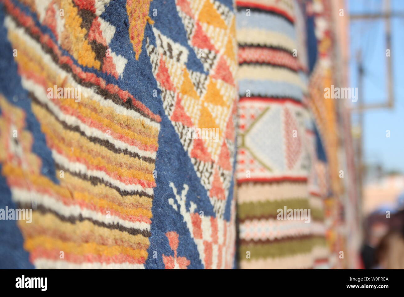 Colourful woven rugs hanging from a wall in Marrakesh Stock Photo