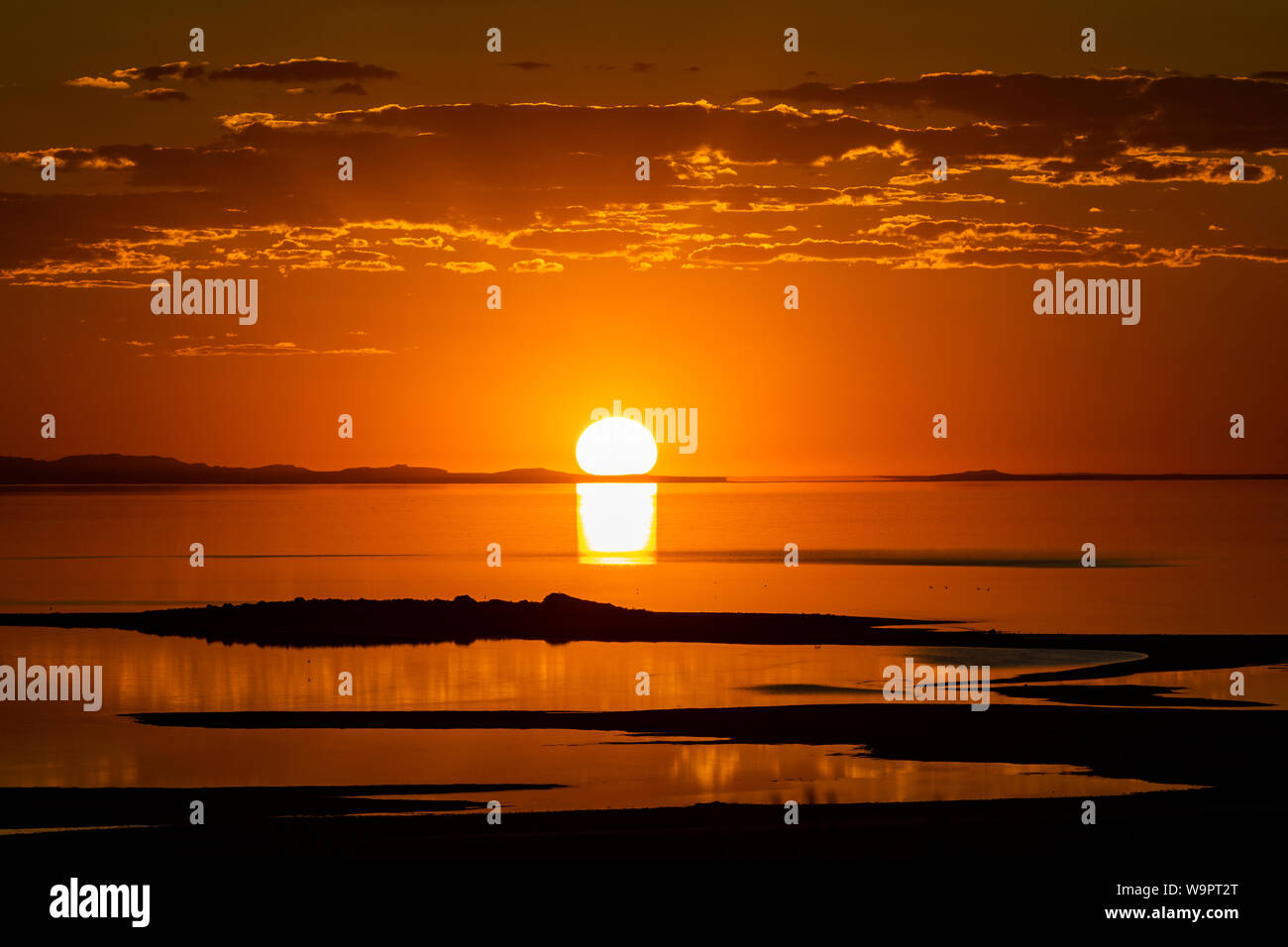 The summer sun sets over the Great Salt Lake as seen from the Bridger Bay area of Antelope Island State Park, Utah, USA. Stock Photo