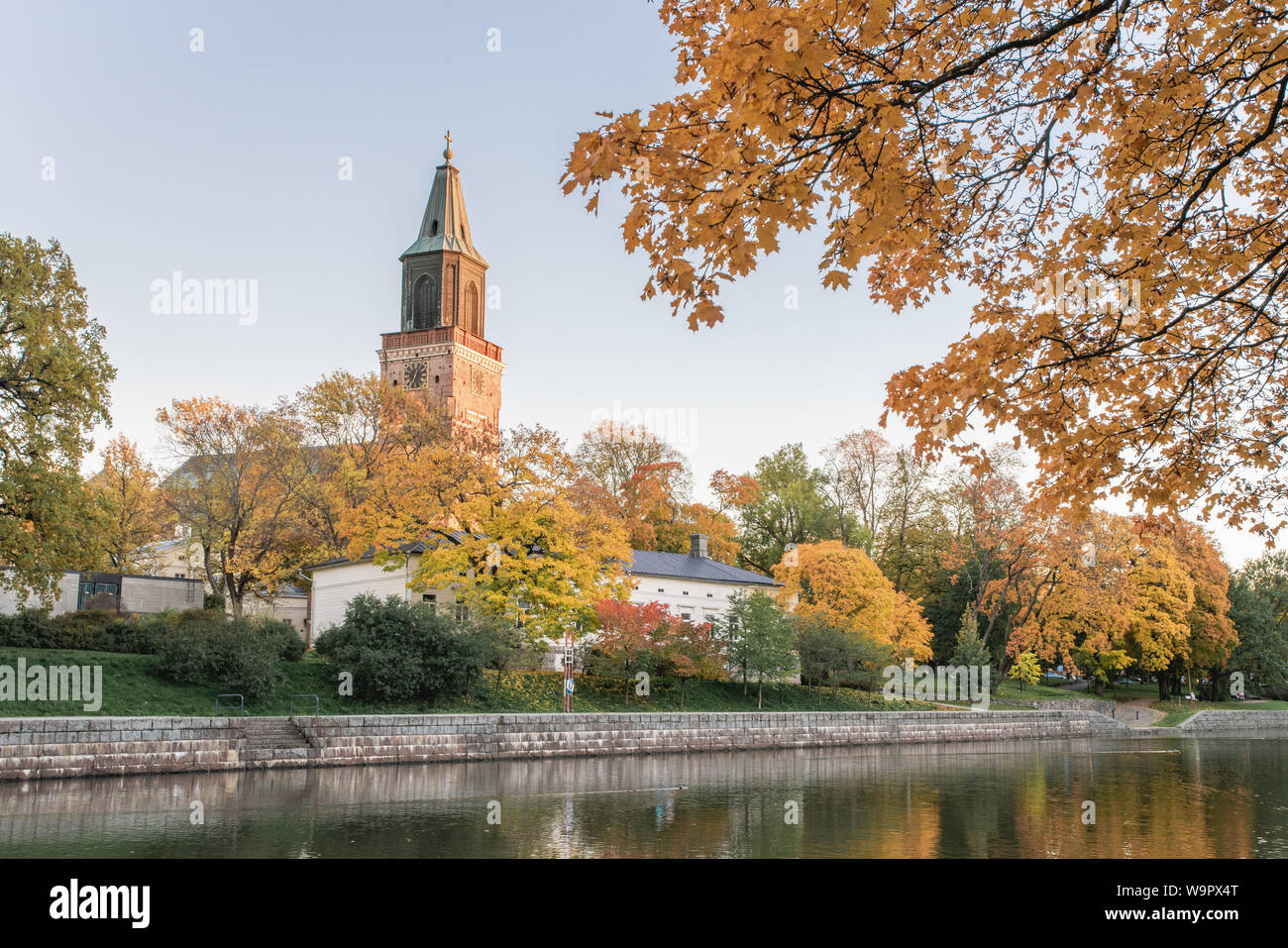 Beautiful fall foliage and Aura river against clear blue sky with Turku Cathedral in the background in Turku, Finland, Autumn 2018 Stock Photo