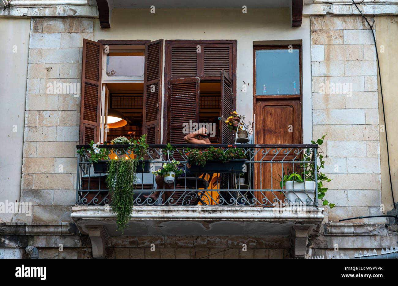 Tel Aviv, Israel- June 17, 2019 :Man resting on a balcony in an old house Stock Photo