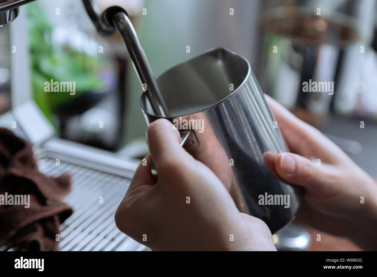 https://c8.alamy.com/comp/W9R03C/use-the-steam-of-the-coffee-machine-to-heat-pure-milk-cafe-in-summer-hold-the-milk-cylinder-with-both-hands-heat-milk-with-steam-W9R03C.jpg