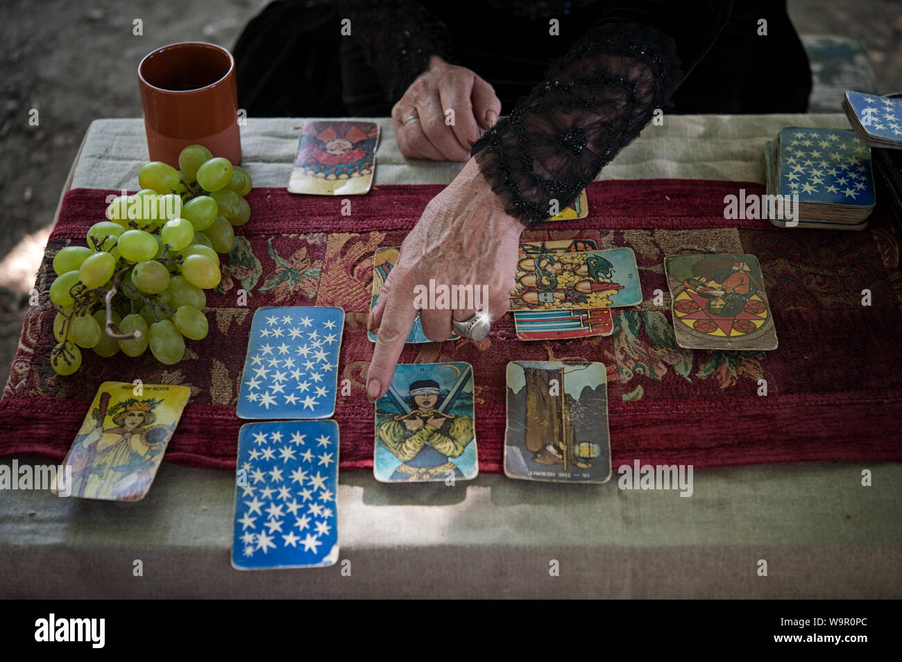 Volterra, Italy - 2019, August 11: Occult priest during a private session. Tarot readings is an ancient form of divination and prediction of the futur Stock Photo