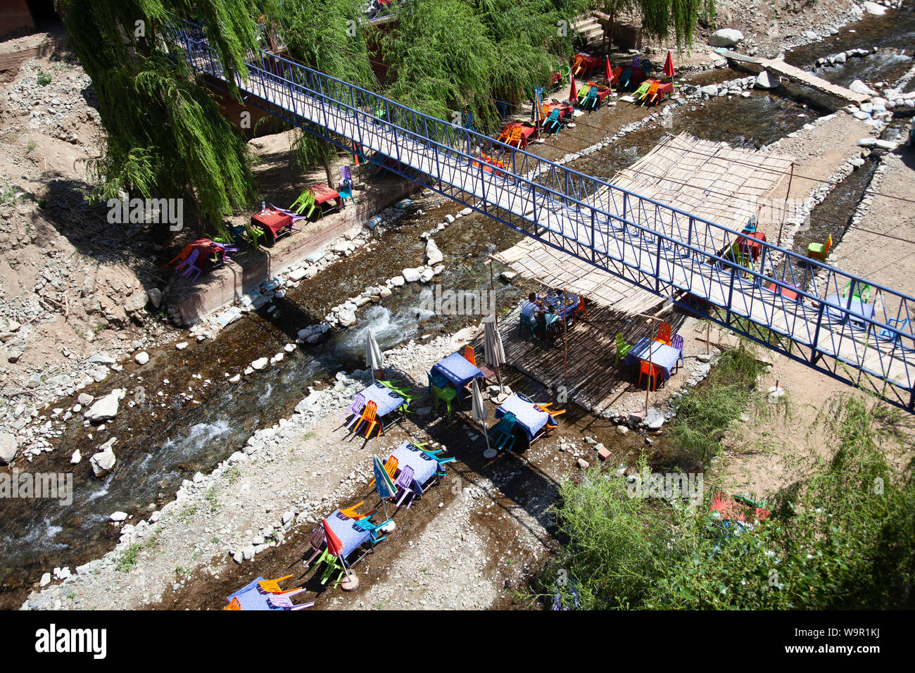 People Sit at Restaurants on the River at Sti Fadma, Ourika Valley in the Atlas Mountains, Morocco Stock Photo