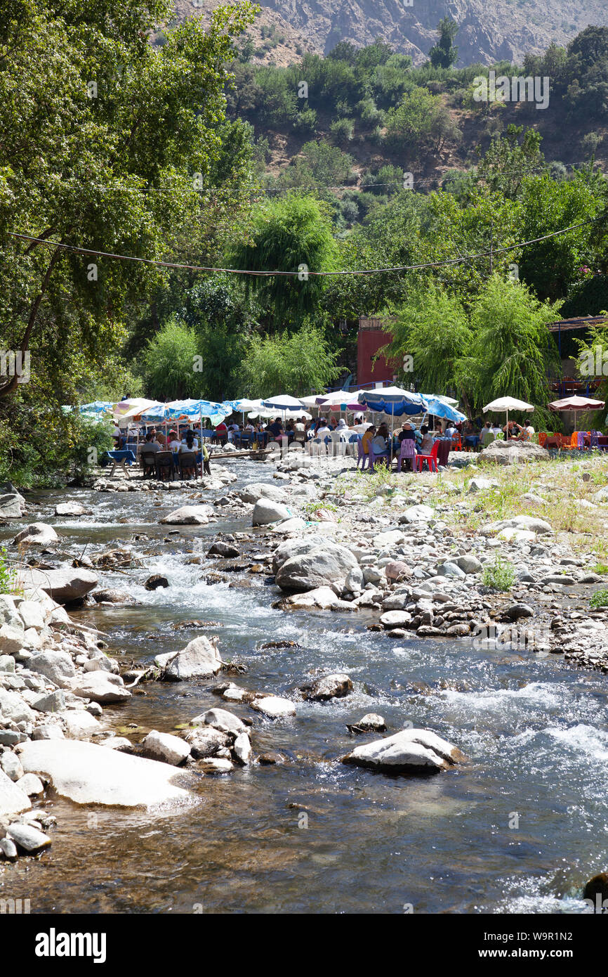 People Sit at Restaurants on the River at Sti Fadma, Ourika Valley in the Atlas Mountains, Morocco Stock Photo