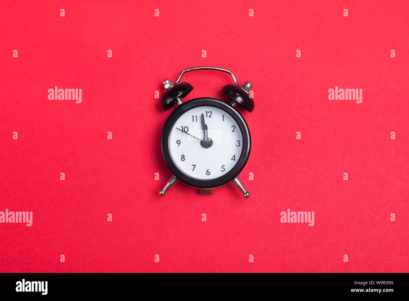 Small vintage alarm clock on the red background Stock Photo
