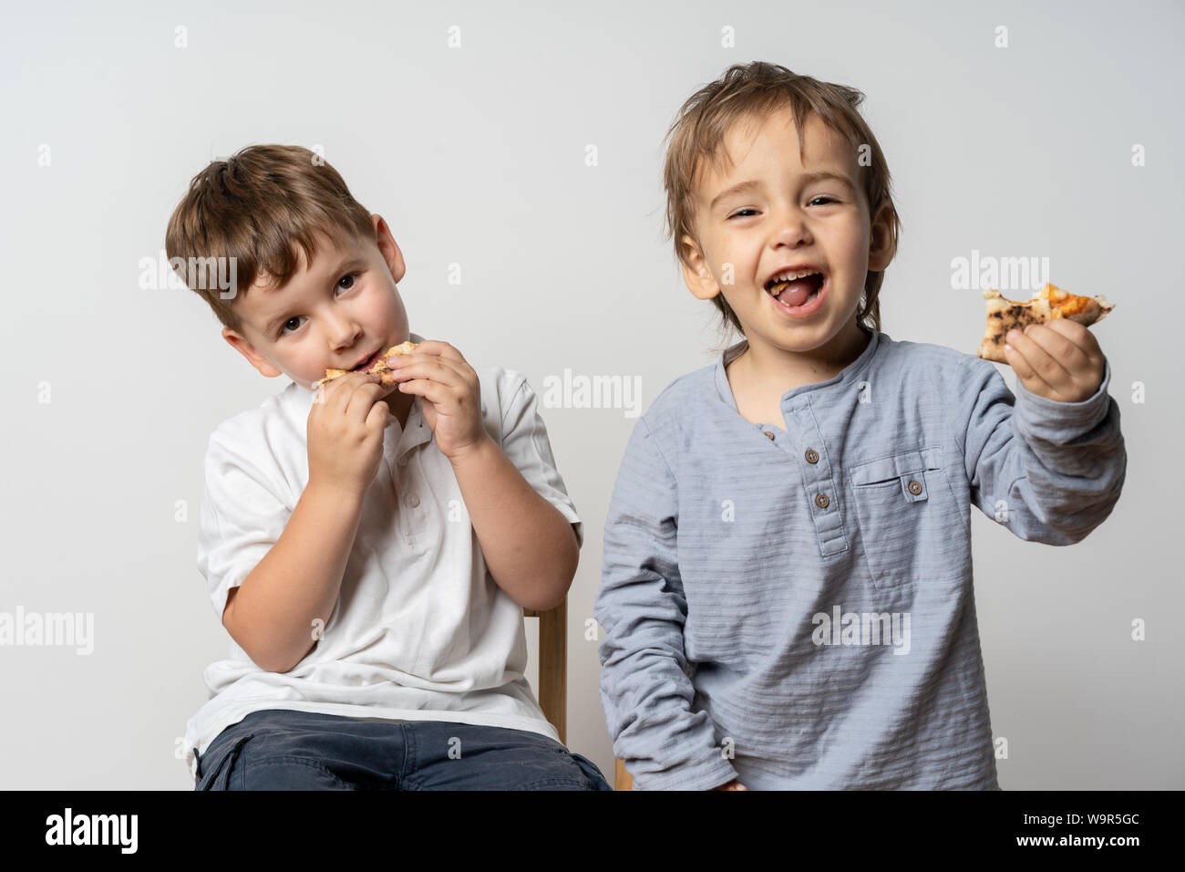 Little children having lunch outdoors. Having a lot of fun. Two cute boys. Stock Photo