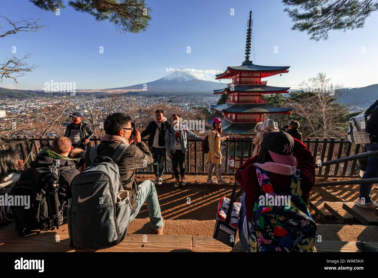 Tourists at a viewpoint, view of five-storey pagoda, Chureito pagoda with Fujiyoshida City and Mount Fuji volcano, Yamanashi Prefecture, Japan Stock Photo
