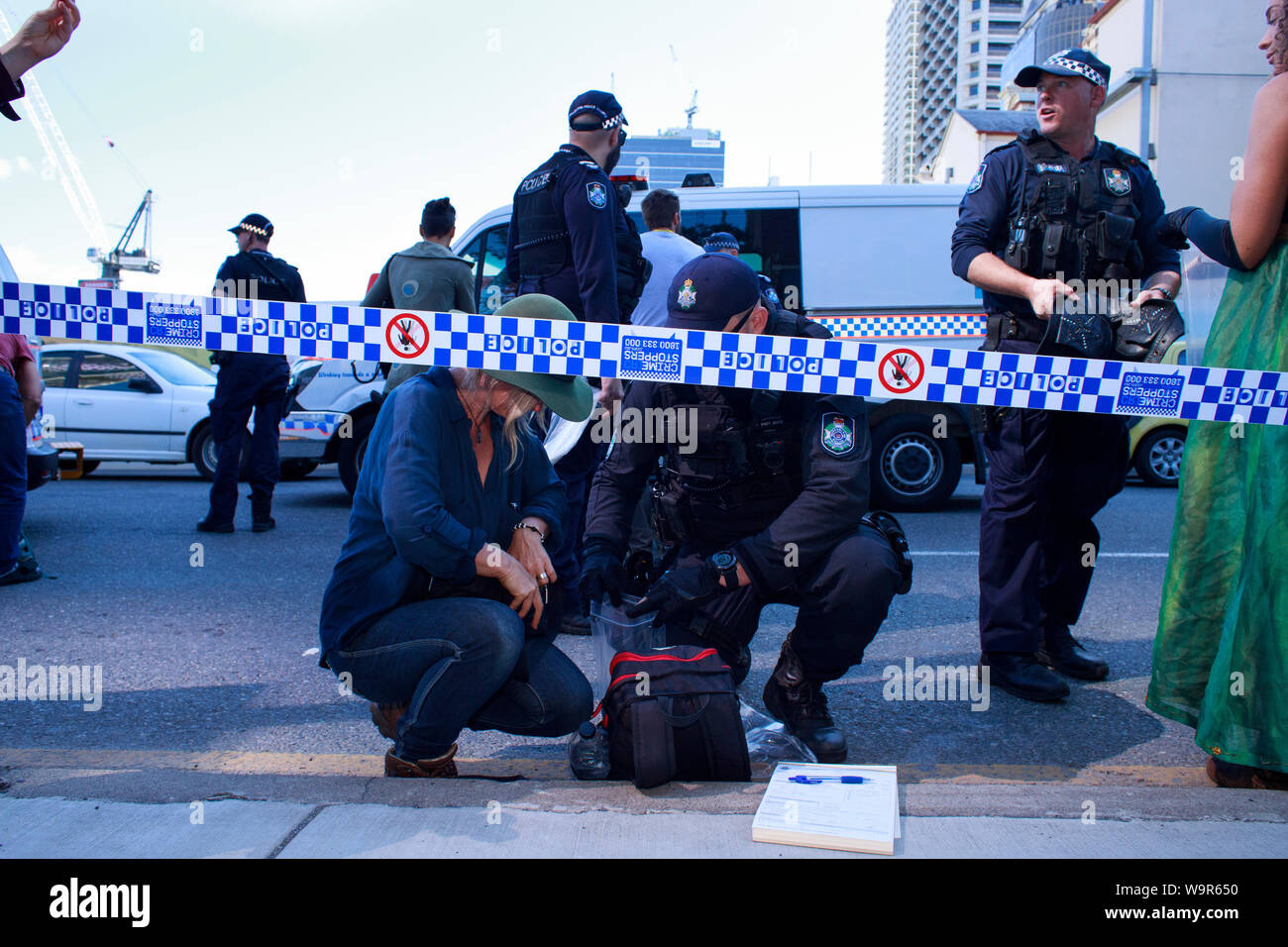 Police confiscate the belongings of a woman arrested for traffic disruption and civil disobedience during the Extinction Rebellion protest in Brisbane. Stock Photo