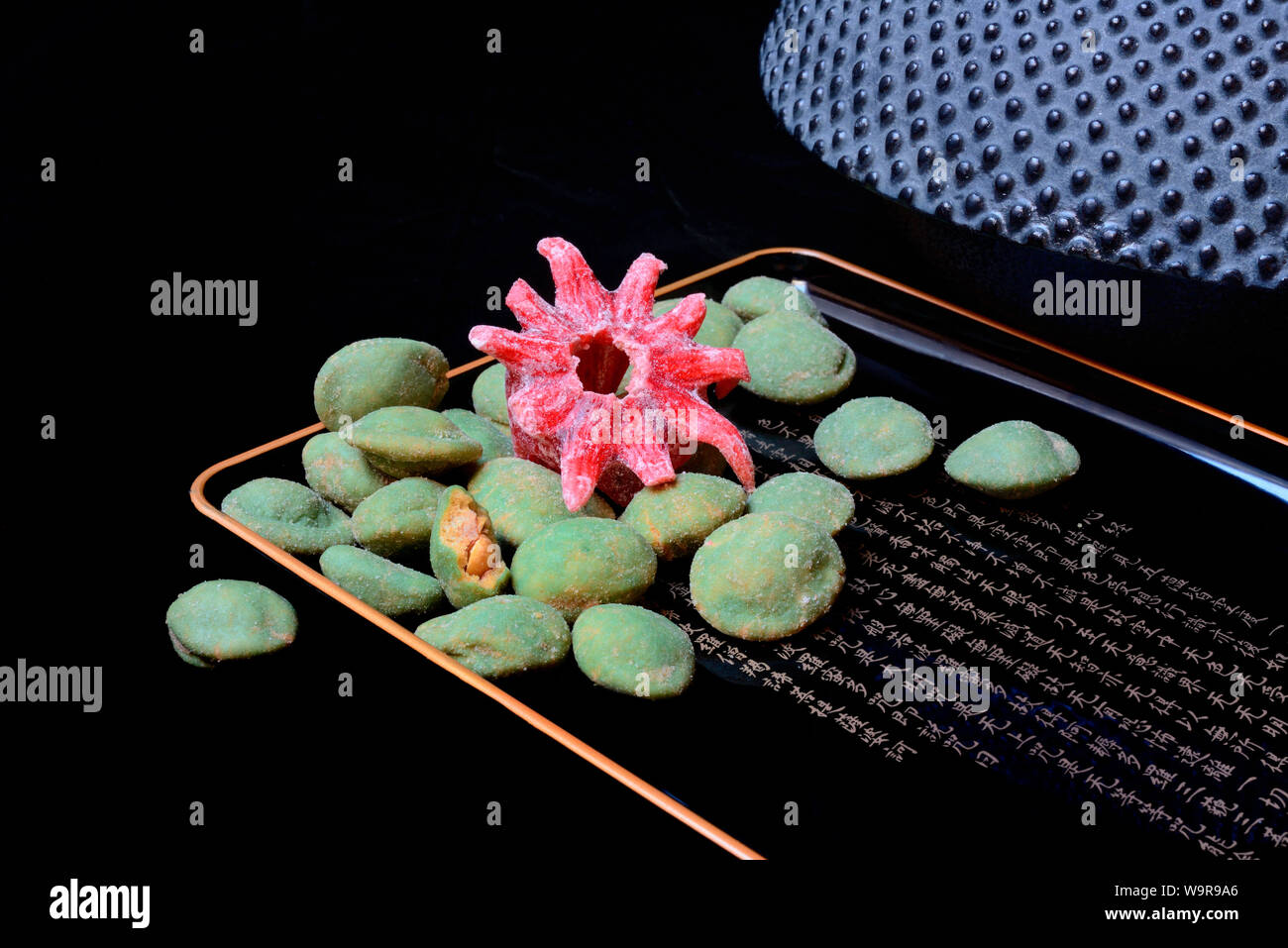 Wasabi peanuts and candied hibiscus blossom Stock Photo