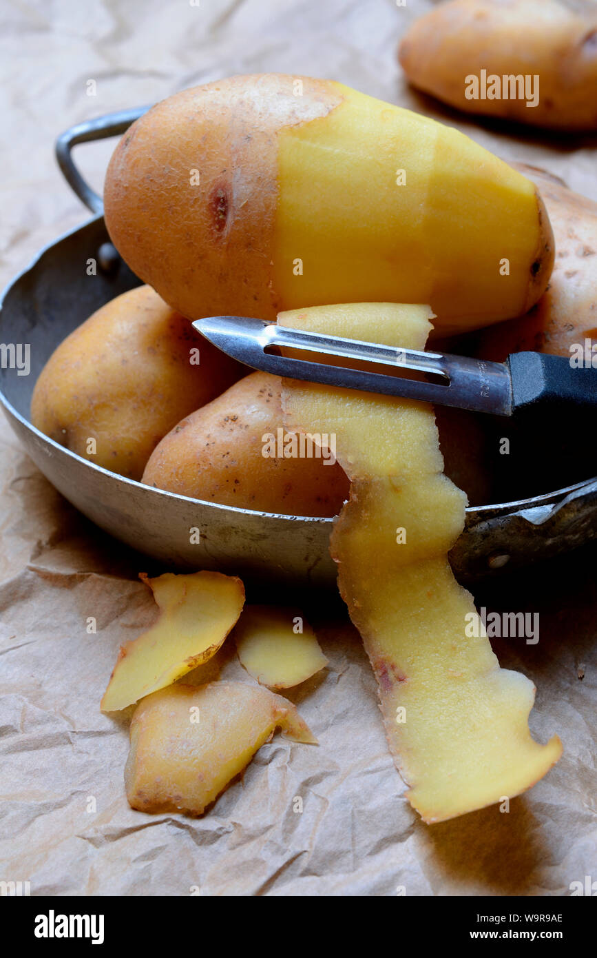 peeling potato with potato peeler Stock Photo