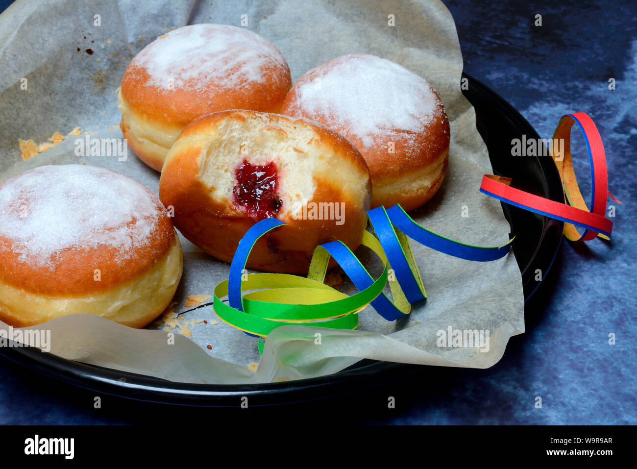 Berliner Pfannkuchen mit Luftschlangen, angebissen Stock Photo - Alamy Berliner Pfannkuchen mit Luftschlangen, angebissen Stock Photo - Alamy