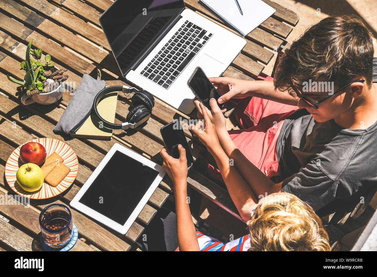 Friends having fun playing with tech modern device. Young boy making  homework together. Generation z student using laptop, tablet and  smartphones Stock Photo - Alamy