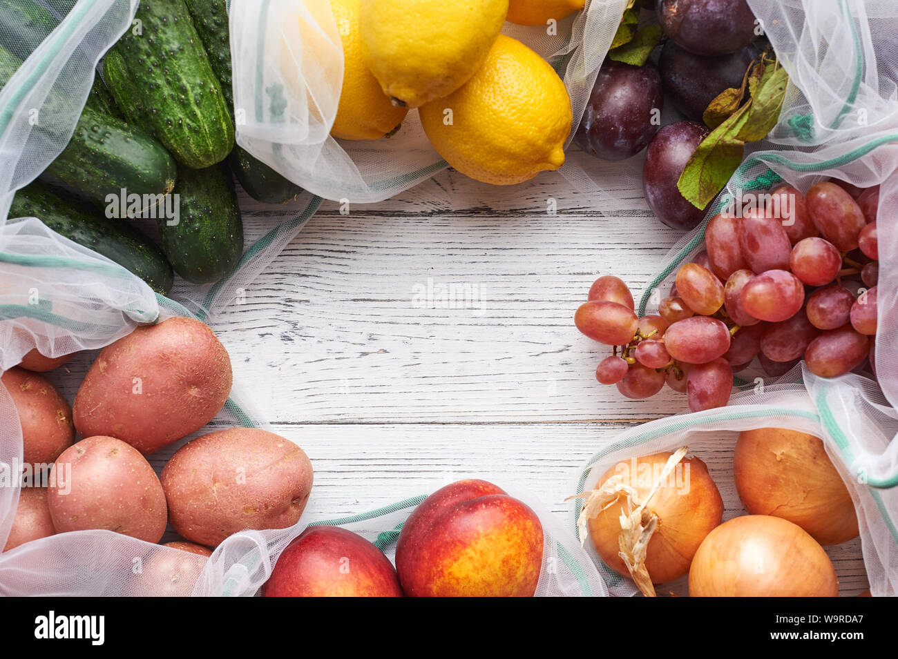 Frame of fruits and vegetables in reusable eco bags at white wooden ...