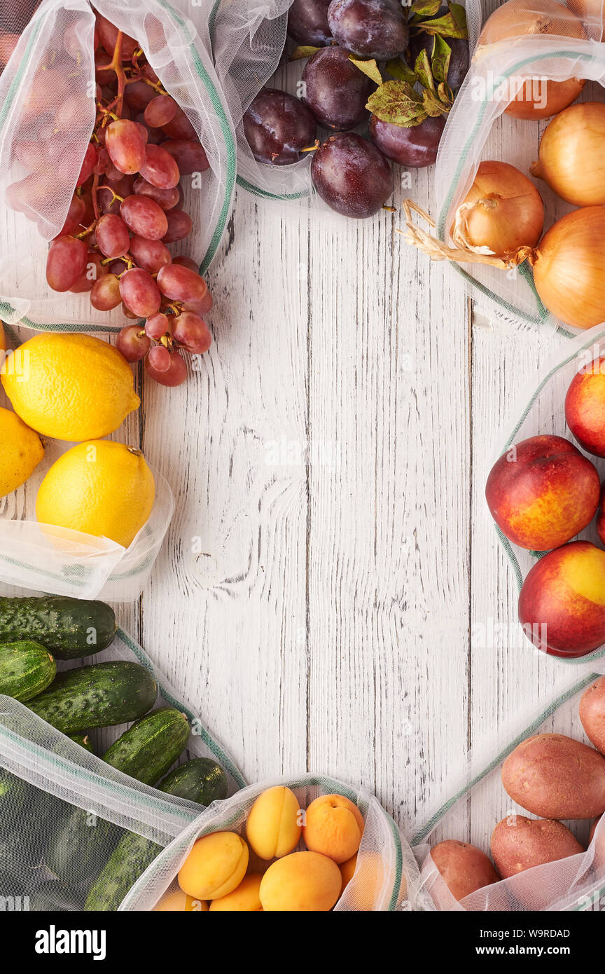Frame of fruits and vegetables in reusable eco bags at white wooden ...
