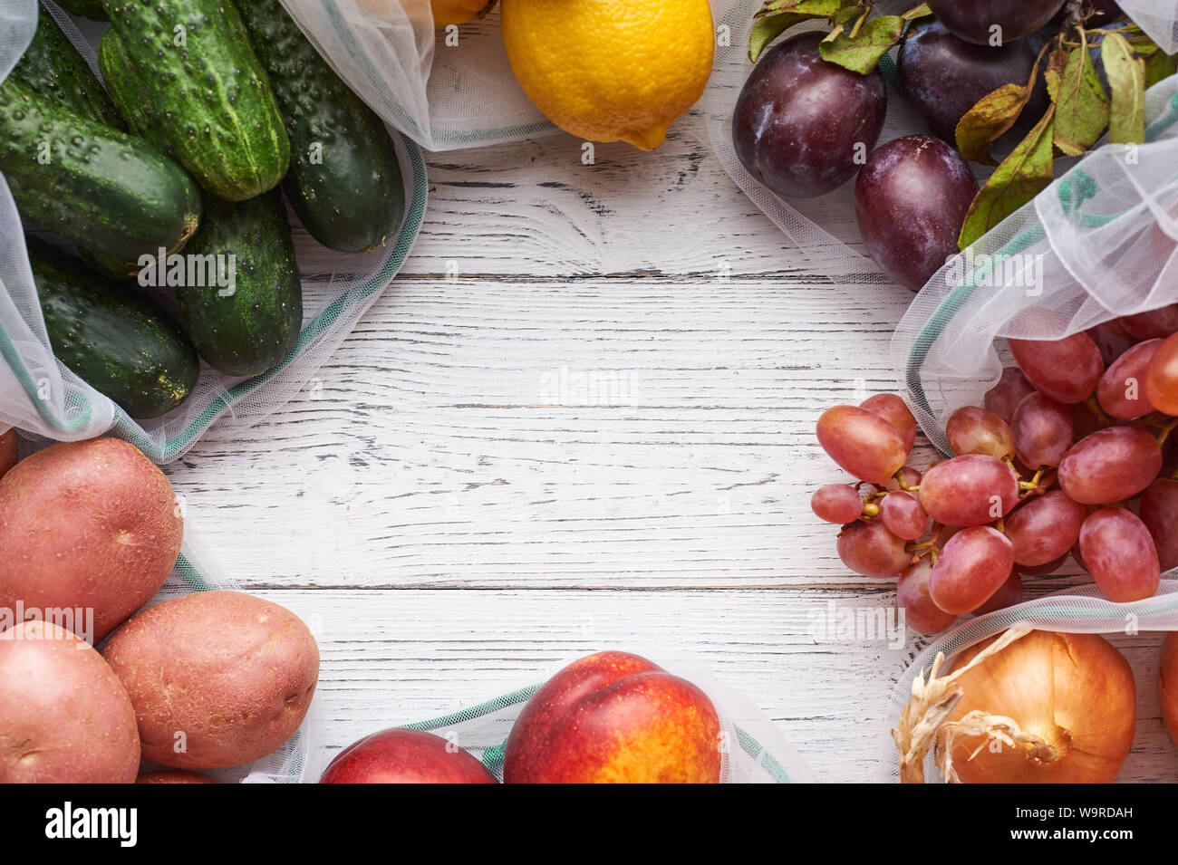 Frame of fruits and vegetables in reusable eco bags at white wooden ...