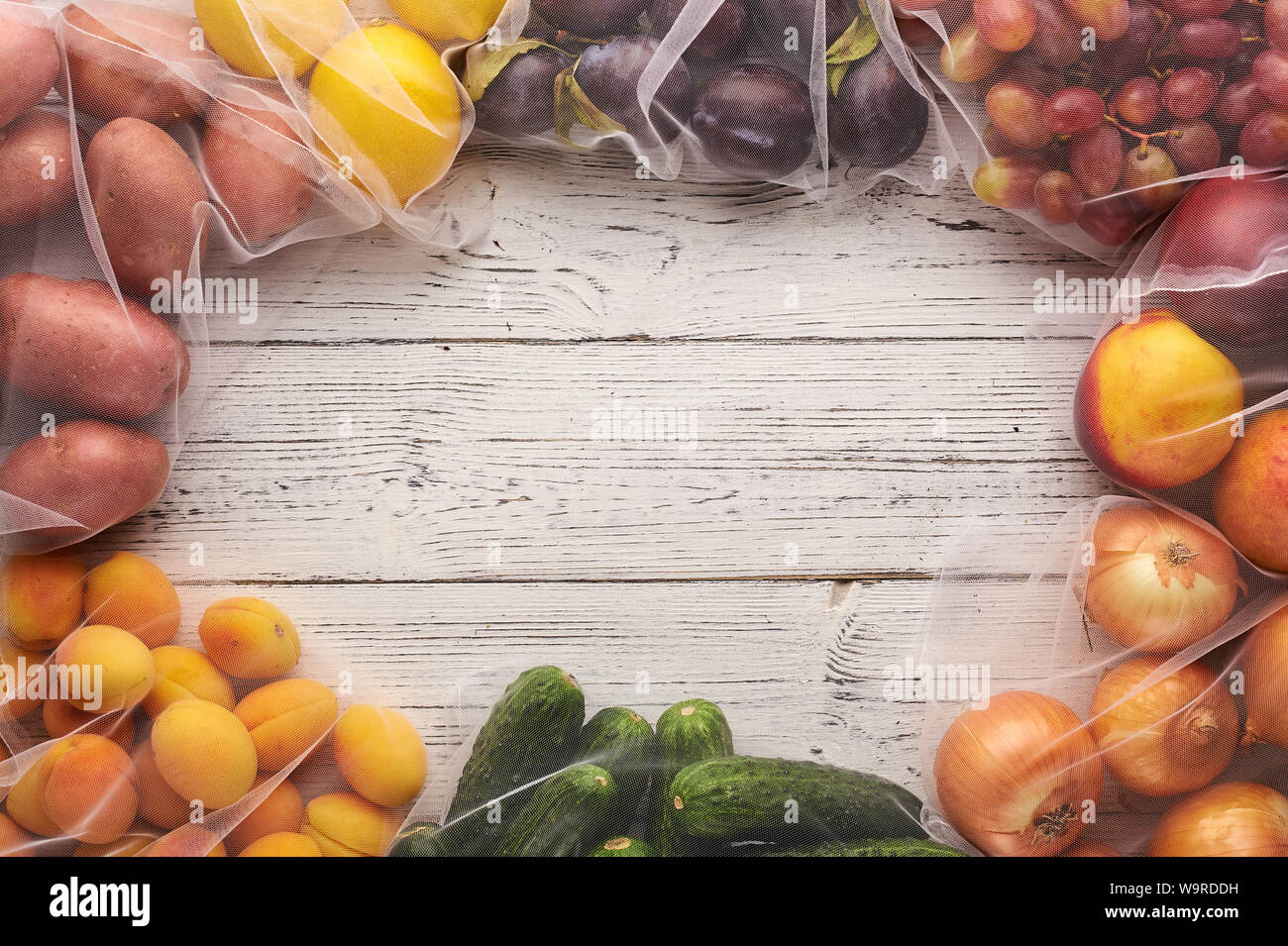 Frame of fruits and vegetables in reusable eco bags at white wooden ...