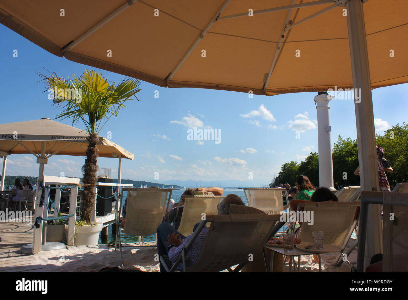 Beach chairs under sunshines with view onto lake. Lazy mood on sunny day. Stock Photo