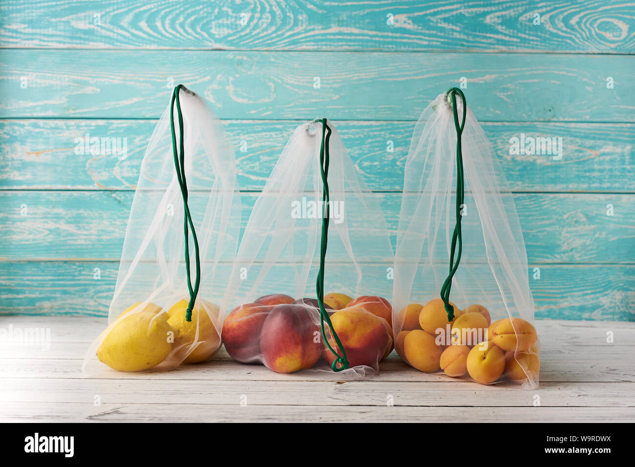 Fruits n reusable eco bags at blue wooden background. Recycled bags ...