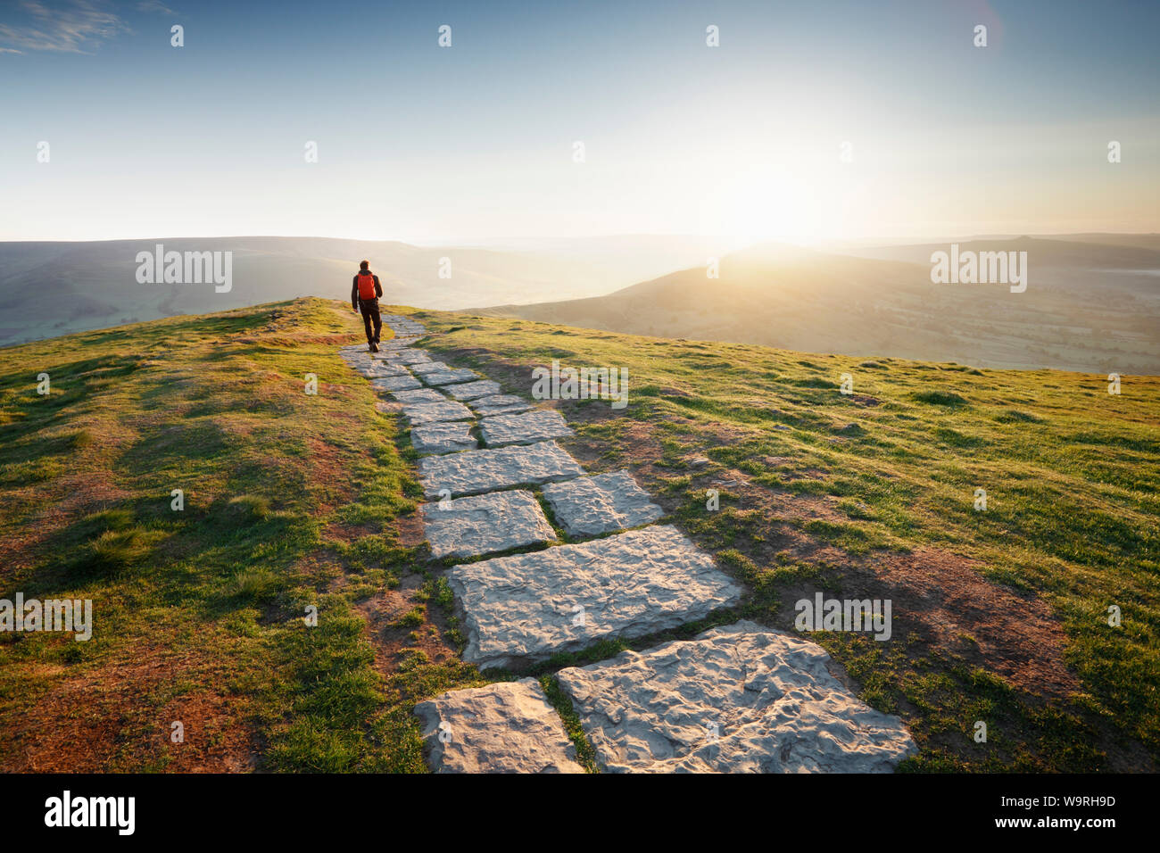 Lone walker on the Footpath from Mam Tor to Lose Hill. Sunrise. Peak District National Park. Derbyshire. UK. Stock Photo