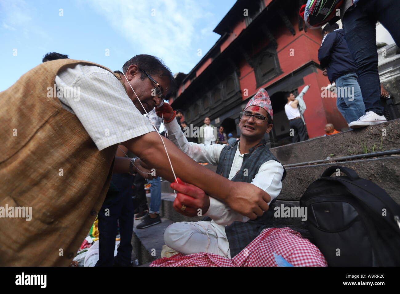Kathmandu, Nepal. 15th Aug, 2019. A man changing the sacred thread