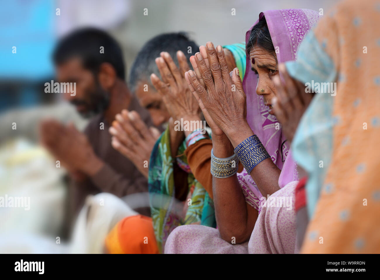 Devout Hindu pilgrims pray on the ghats of the sacred river Narmada in Maheshwar, India Stock Photo