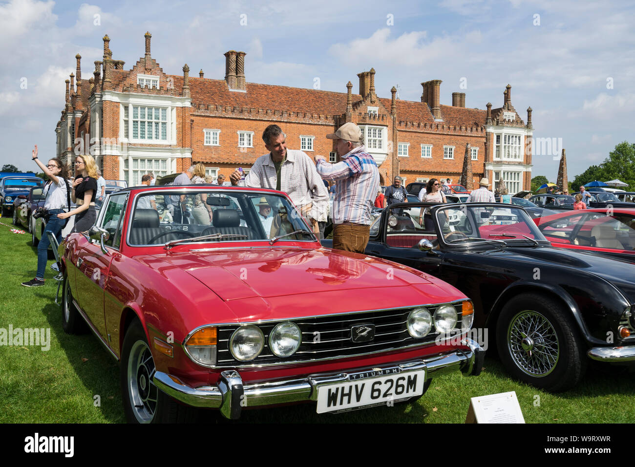 Owner and spectator discussing 1974 Triumph Stag Mk II at The Helmingham Festival of Classic & Sports Cars 2019 Stock Photo