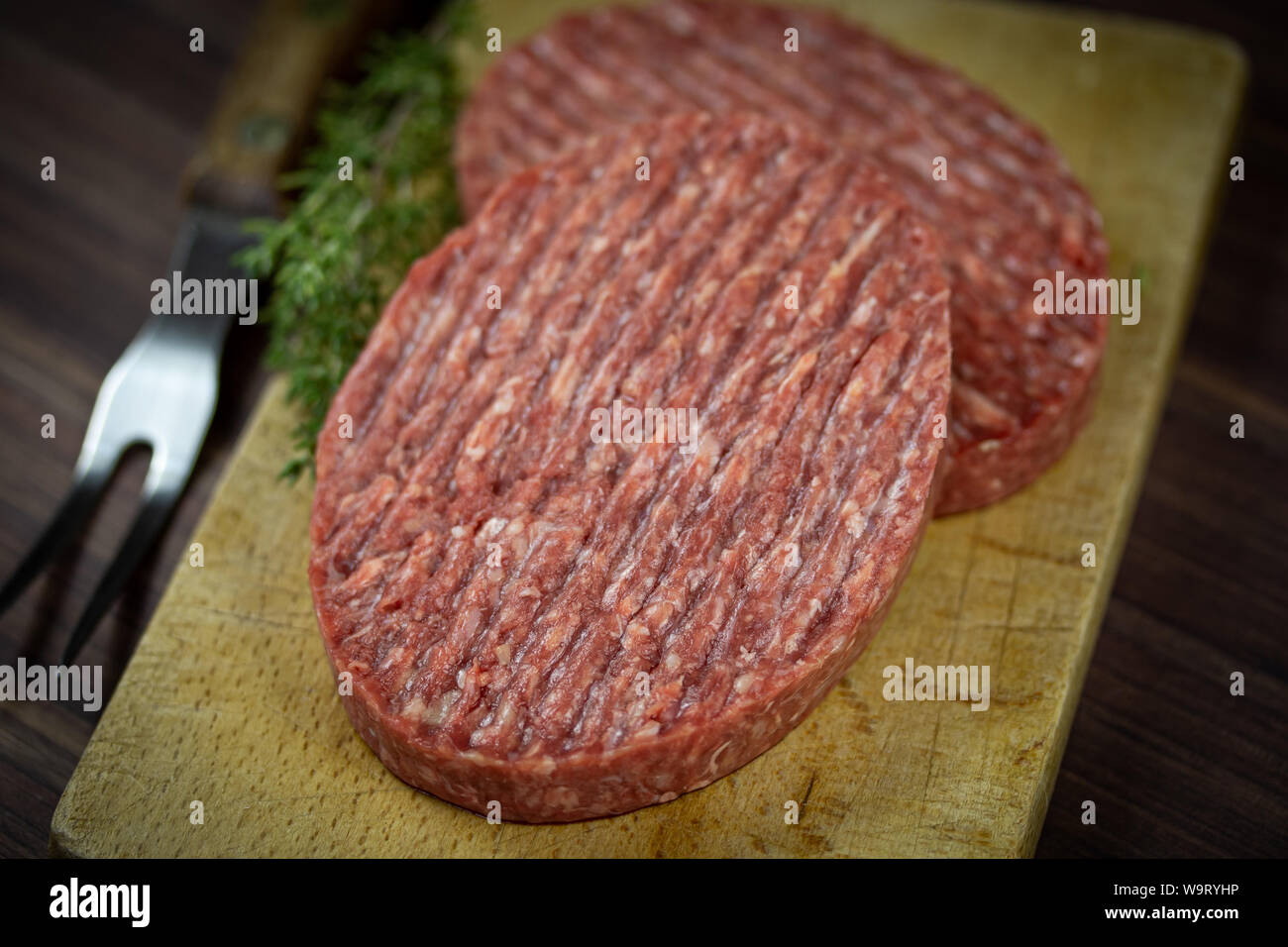 raw beef ground steaks on a cutting board Stock Photo Alamy