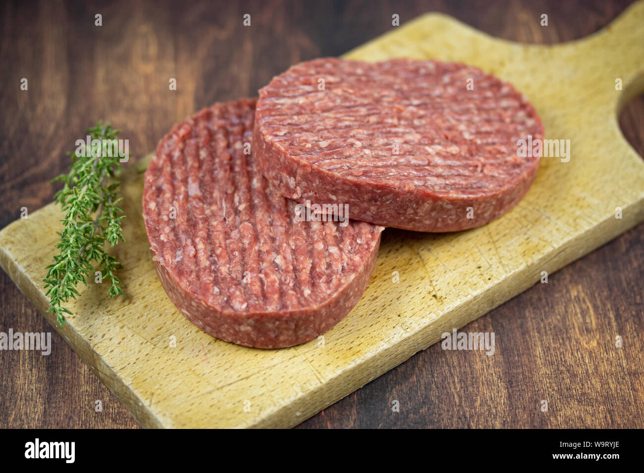 raw beef ground steaks on a cutting board Stock Photo Alamy