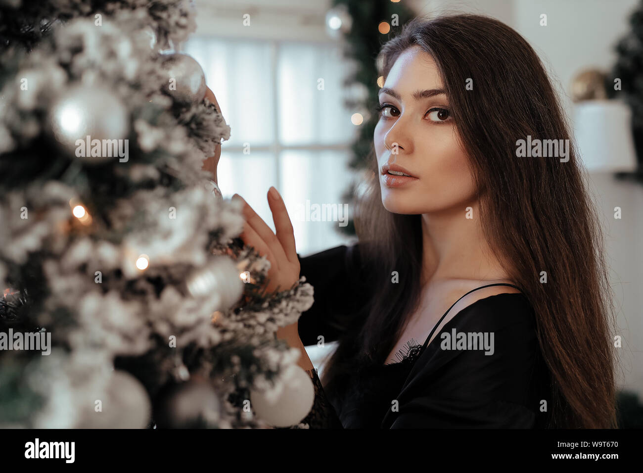 Fashion. Beautiful woman by the Christmas tree Stock Photo - Alamy