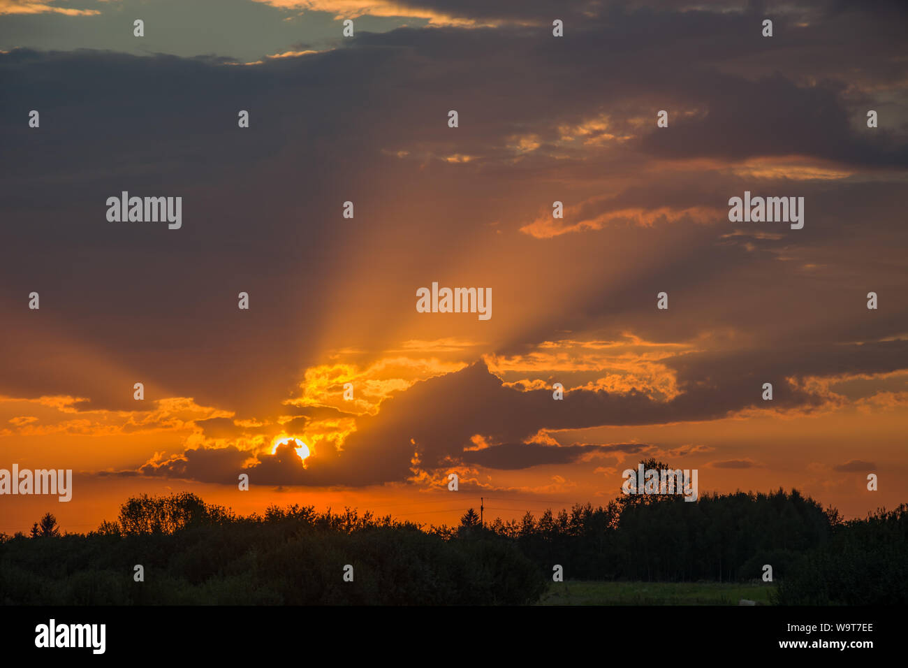 Sun rays and the sun behind the clouds. Nowiny, Poland Stock Photo