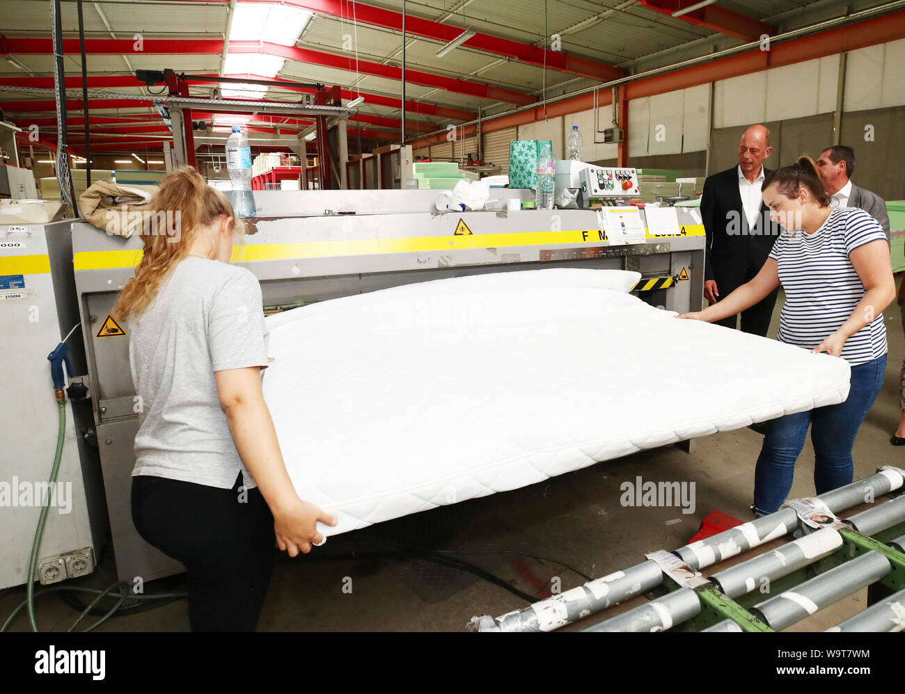 Weida, Germany. 15th Aug, 2019. Thuringia's Economics Minister Wolfgang  Tiefensee (SPD) visits Breckle Matratzenwerk Weida GmbH and observes two  employees closing the cover of a foam mattress. Credit: Bodo  Schackow/dpa-Zentralbild/dpa/Alamy Live News
