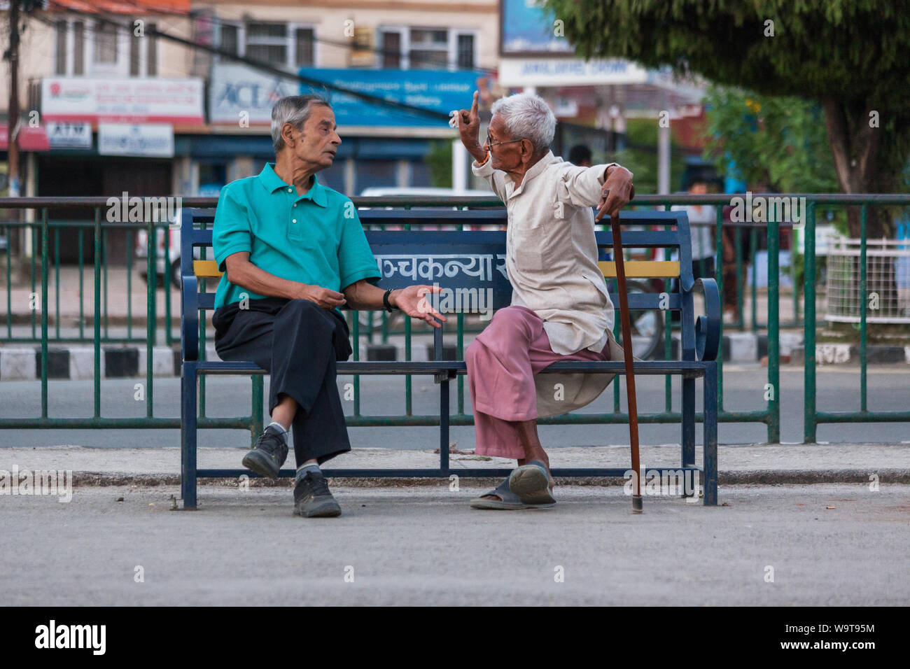 Men sat on a park bench in Pokhara having a debate Stock Photo - Alamy