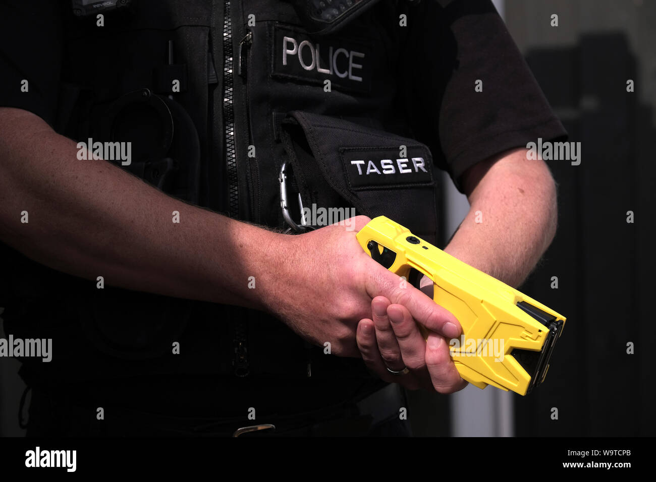 A British police officer holding a axon taser X2 conducted electrical weapon or stun gun. The taser is routinely issued to police forces across the uk Stock Photo