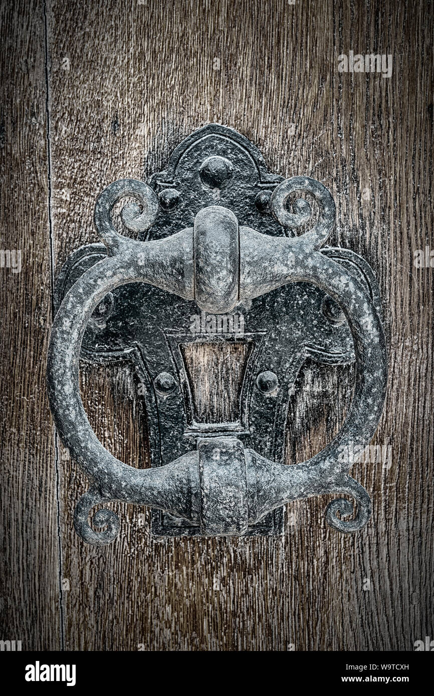 An old classic cast iron Knocker on a wooden door. Stock Photo