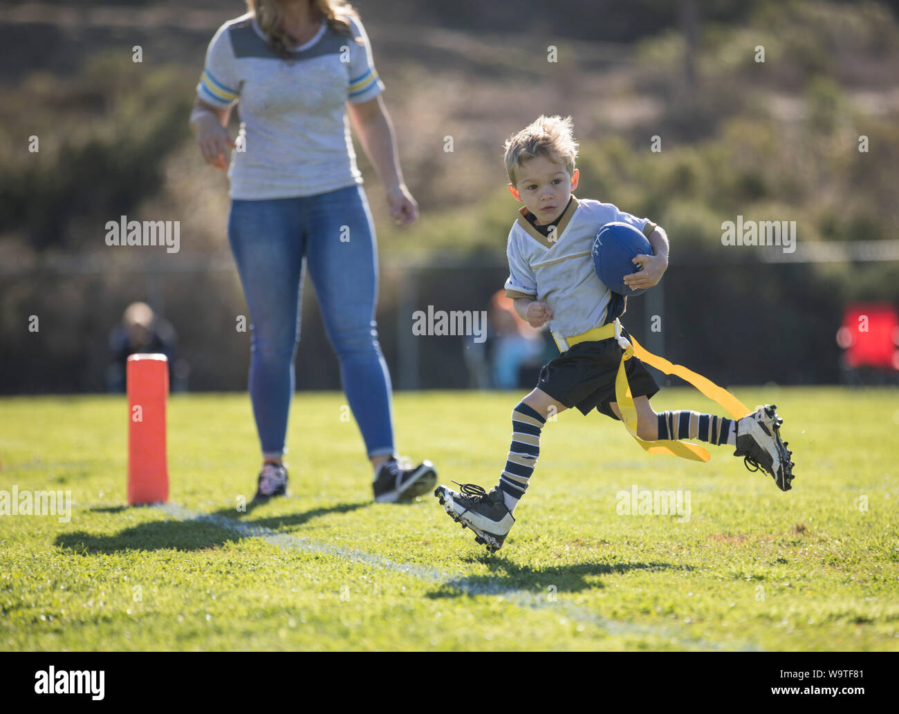 Mother watching her son score a touchdown in flag football, California, United States Stock Photo