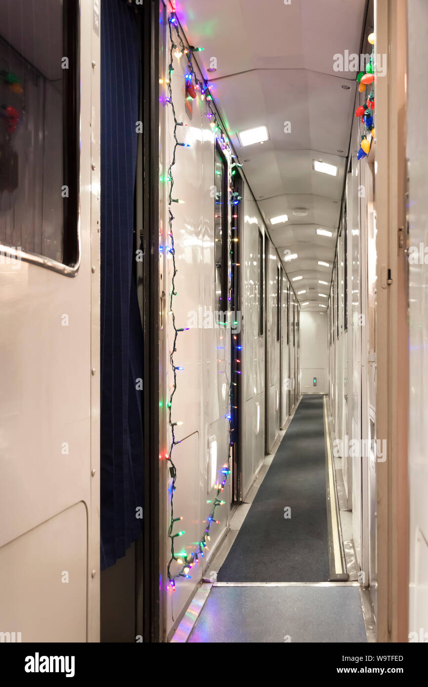 Christmas lights decorate an Amtrak train sleeper car hallway. Stock Photo