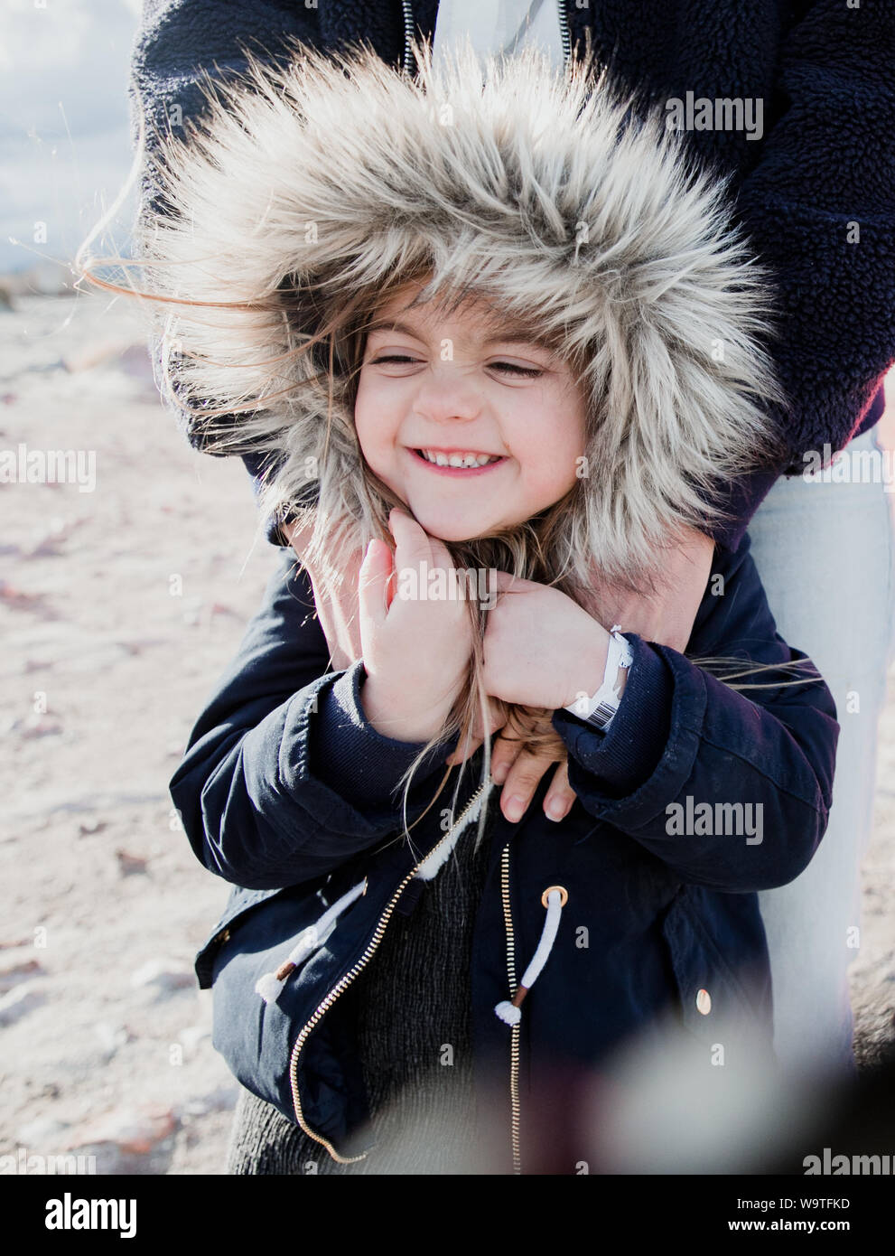 Portrait of a mother hugging her daughter wearing a fake fur hooded jacket, Palm Springs, California, United States Stock Photo