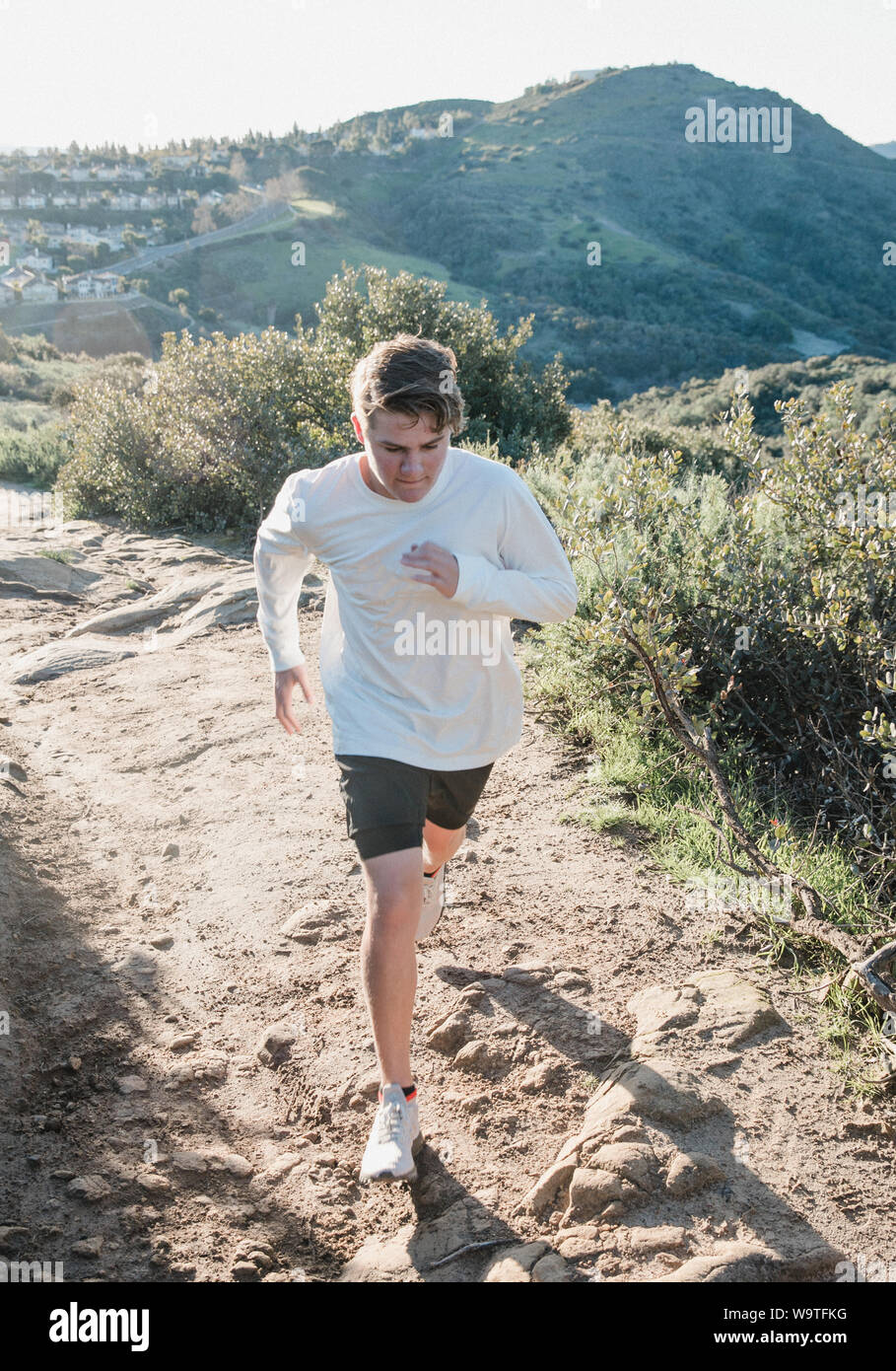Teenage boy running along a desert trail, Palm Springs, California, United States Stock Photo