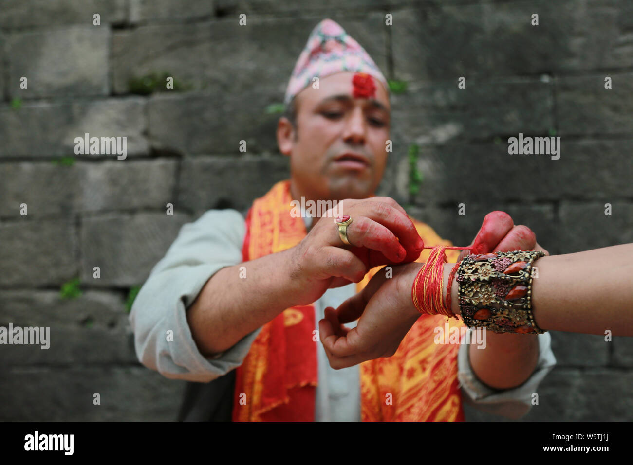 Kathmandu, Nepal. 15 August, 2019. Tying the tread by Hidnu Priest at Pashupatinath Temple. Sarita Khadka/Alamy Live News Stock Photo