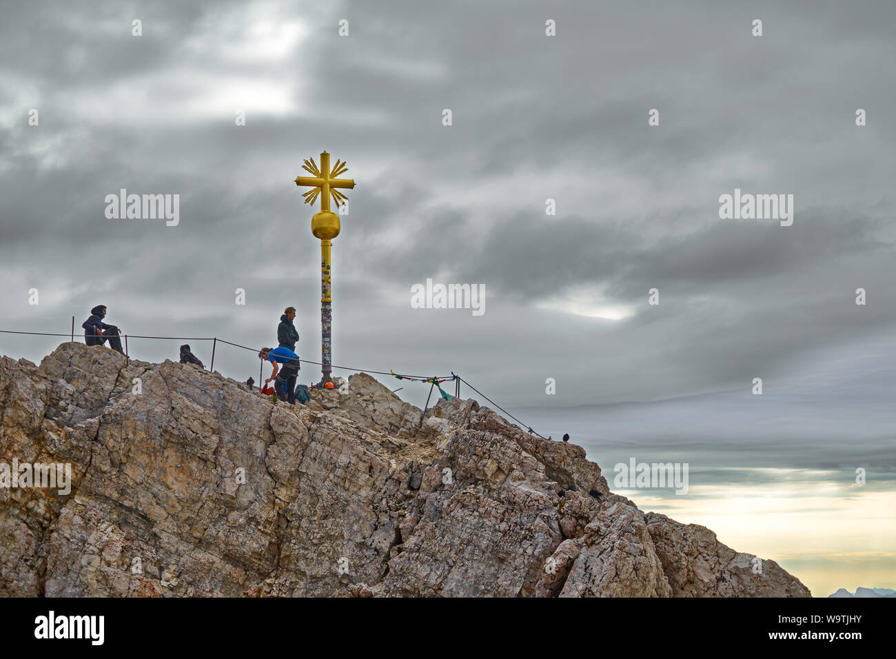 Garmisch-Partenkirchen, Bavaria, Germany, August 9., 2019: summit of the Zugspitze, the highest mountain in Germany, with the golden summit cross Stock Photo