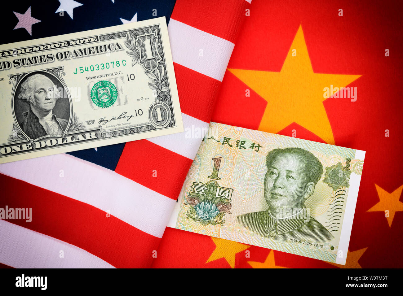 Yuan and dollar banknotes on flags of the USA and China Stock Photo