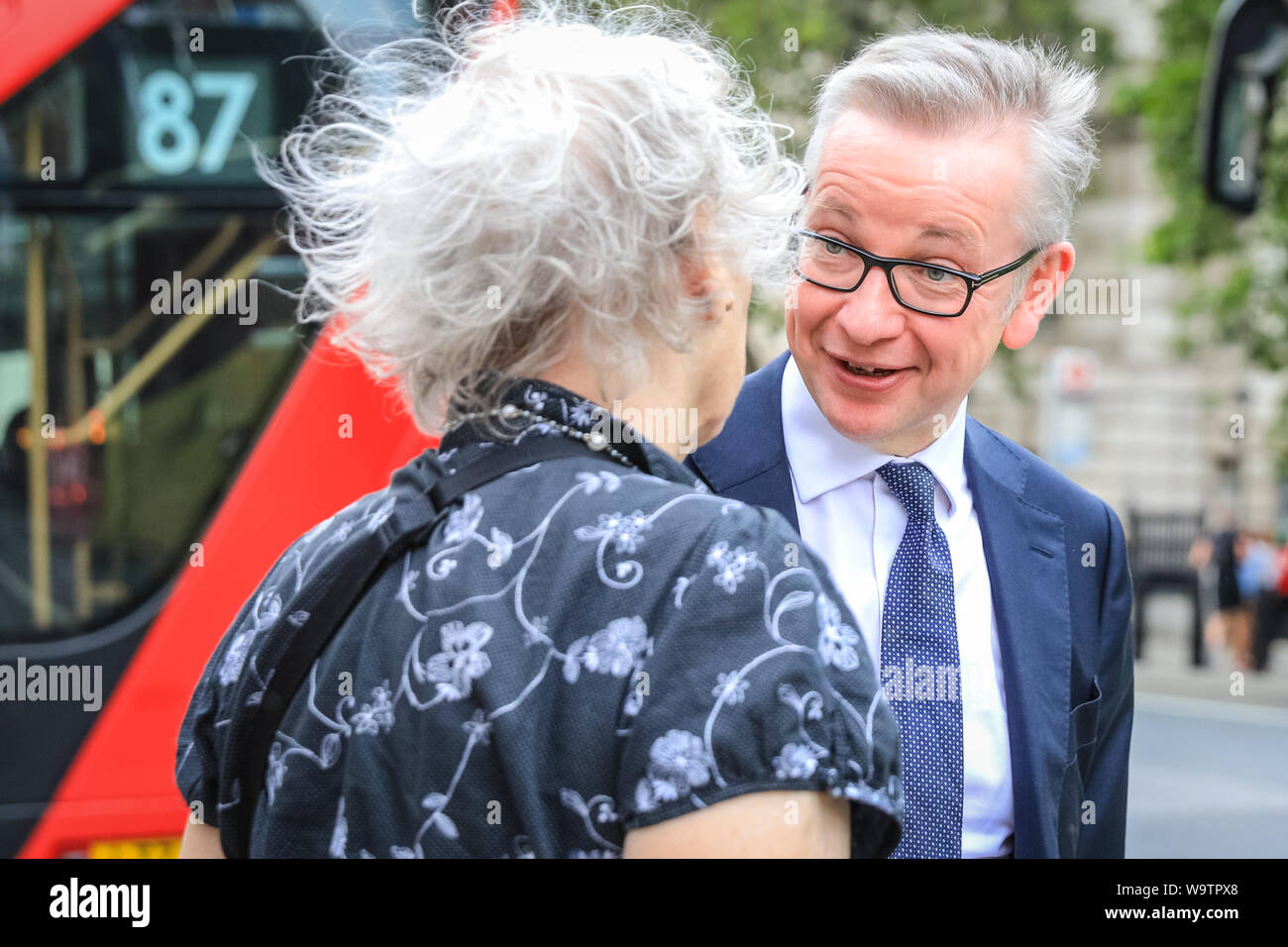 London, UK. 15th Aug, 2019.  Michael Gove, Chancellor of the Duchy of Lancaster with responsibility for no-deal Brexit preparations, as well as overseeing constitutional affairs, maintaining the integrity of the Union and having oversight over all Cabinet Office policy, exits the Cabinet Office in Whitehall and chats to a woman. Credit: Imageplotter/Alamy Live News Stock Photo