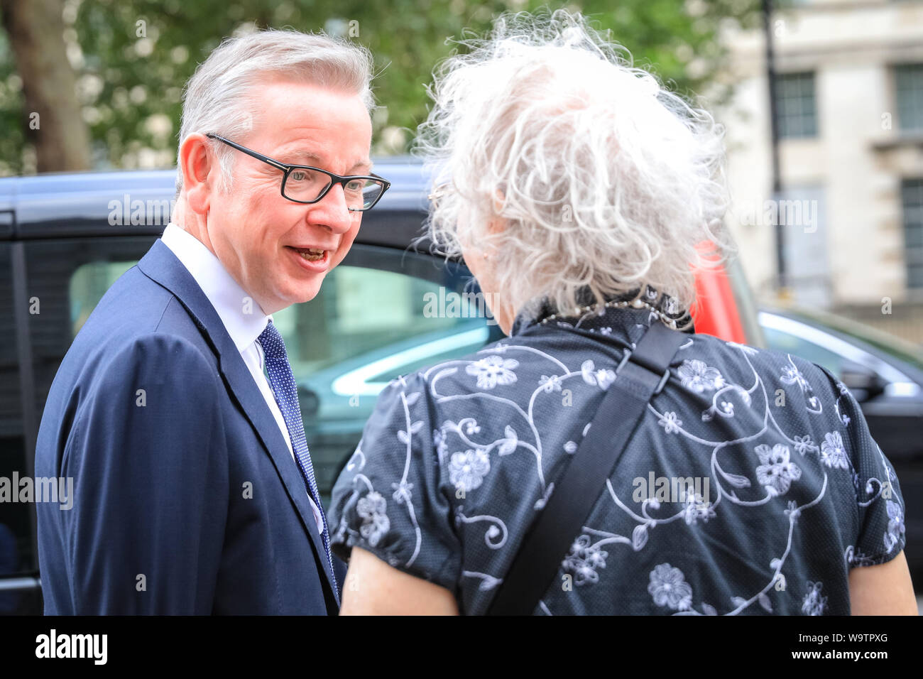 London, UK. 15th Aug, 2019.  Michael Gove, Chancellor of the Duchy of Lancaster with responsibility for no-deal Brexit preparations, as well as overseeing constitutional affairs, maintaining the integrity of the Union and having oversight over all Cabinet Office policy, exits the Cabinet Office in Whitehall and chats to a woman. Credit: Imageplotter/Alamy Live News Stock Photo