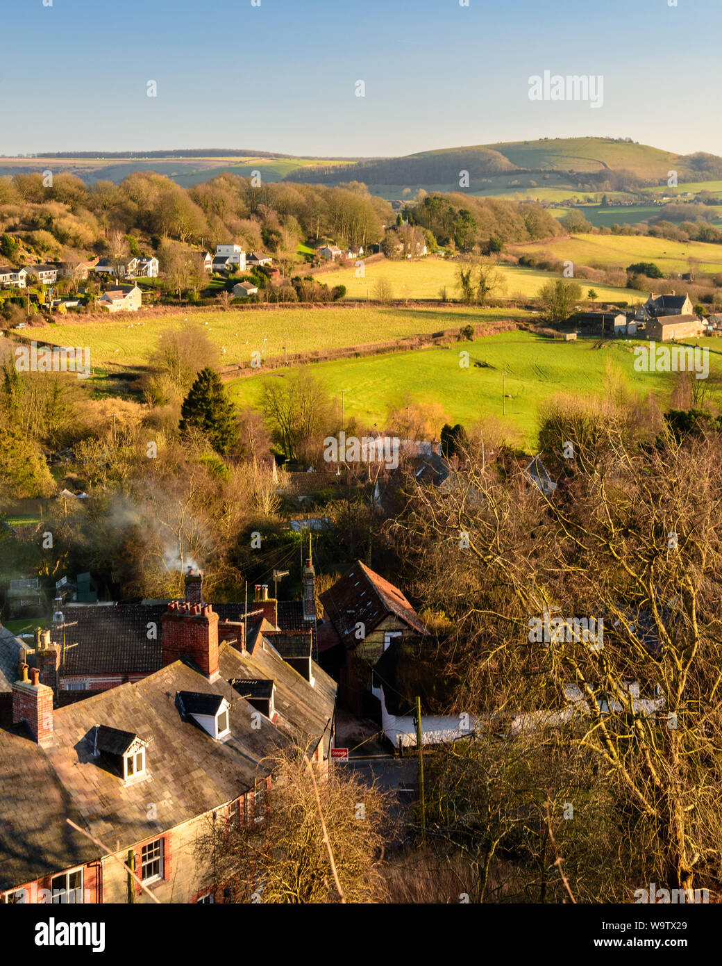 Shaftesbury, England, UK - February 18, 2017: Sun shines on the rooftops of St James's in Shaftesbury, with the rolling hills of Cranborne Chase behin Stock Photo