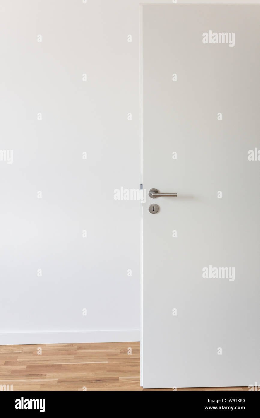 Open White Door With A Gray Chrome Handle And Keyhole Against A