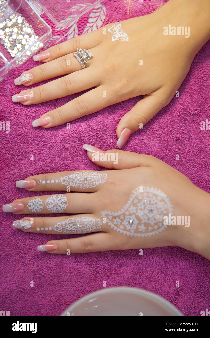 Draws henna into his hands . the master draws in the form of