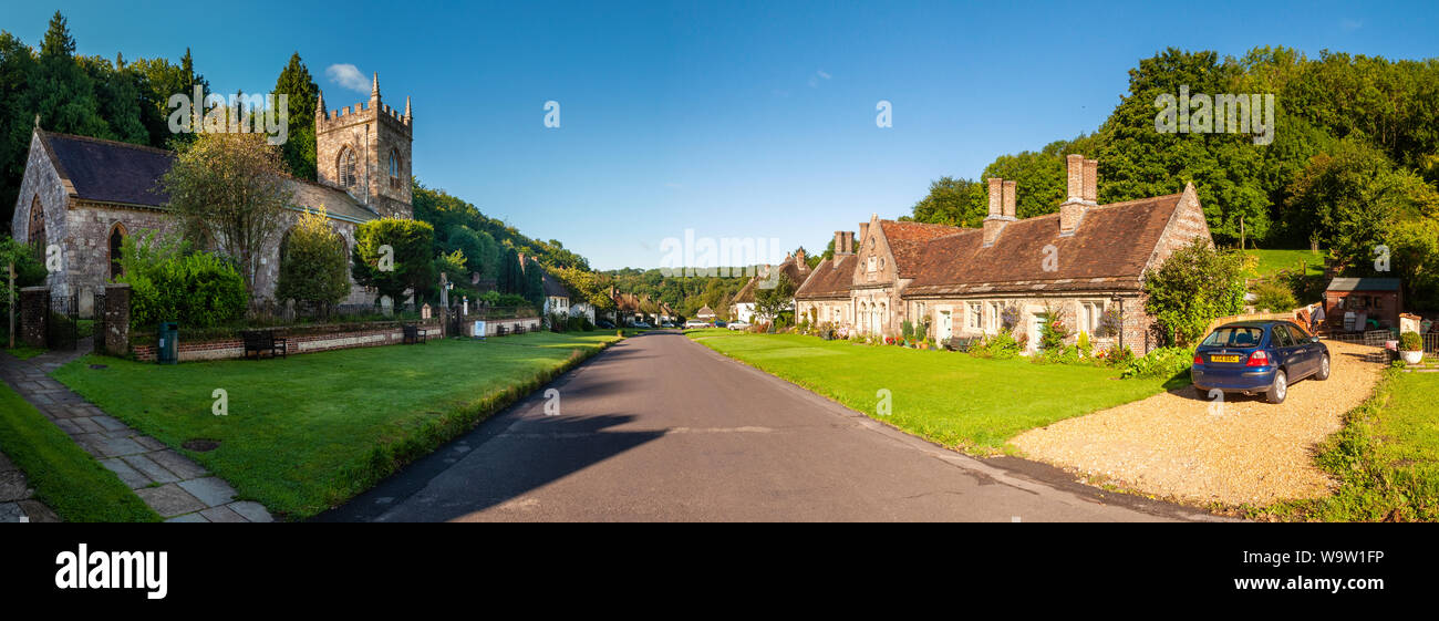 Dorchester, Dorset, UK - August 26, 2012: Summer sun shines on the traditional cottages and parish church of Milton Abbas in Dorset. Stock Photo