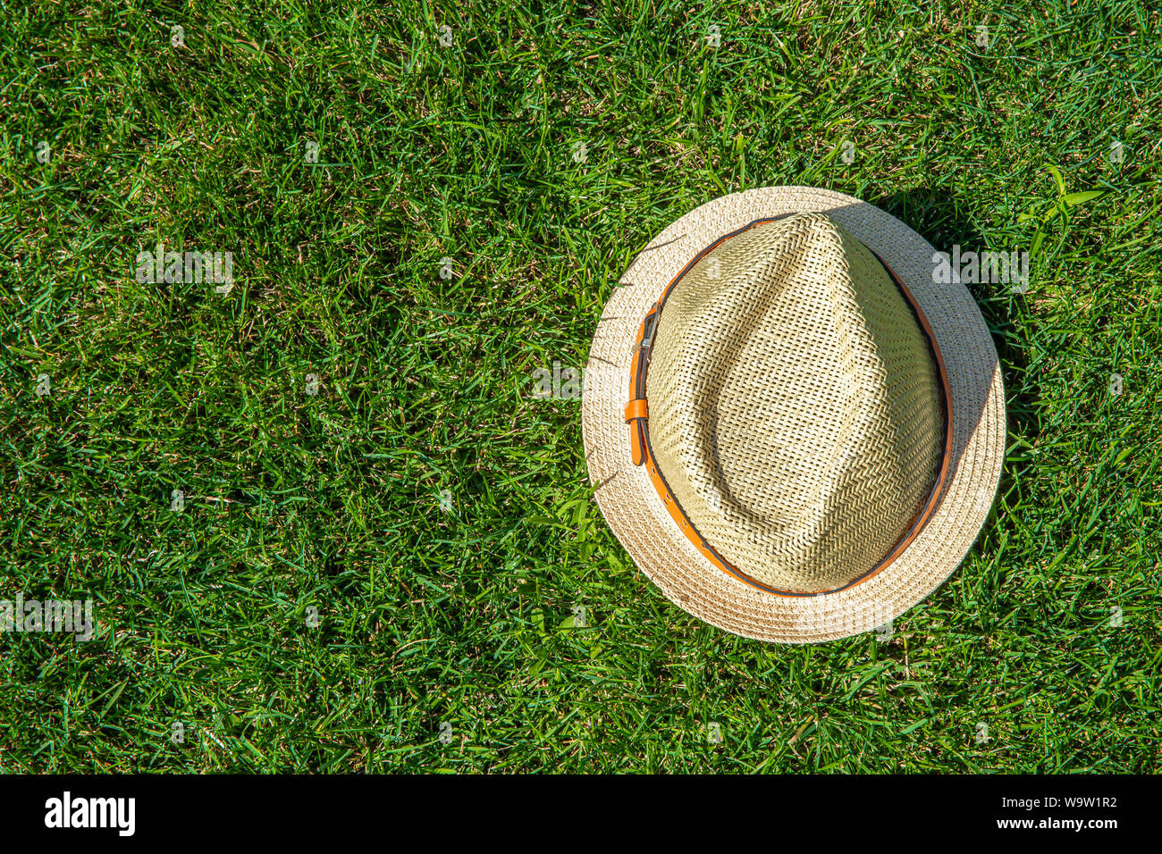 Straw hat on the green grass background with copy space Stock Photo - Alamy