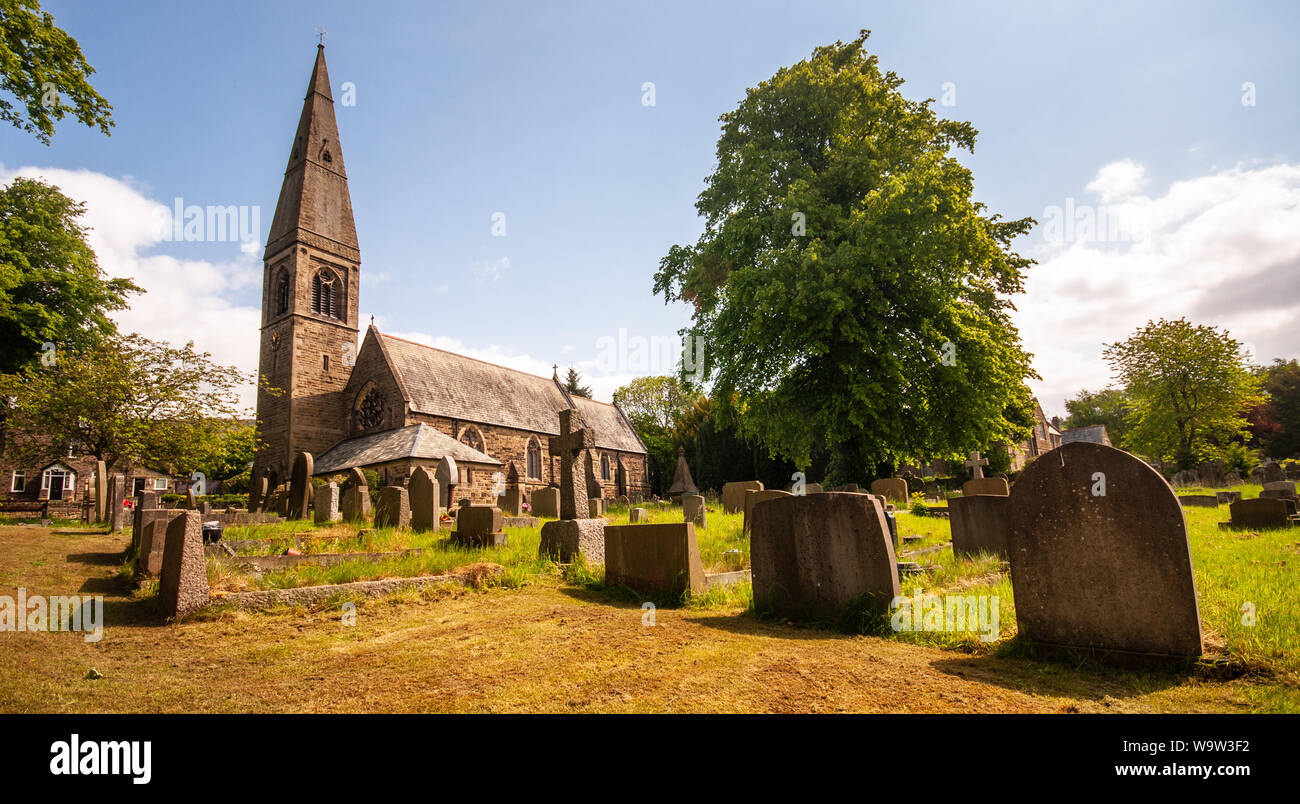 Bamford, England, UK - May 19, 2011: Sun shines on the spire and graveyard of St John's Church in Bamford in the English Peak District. Stock Photo