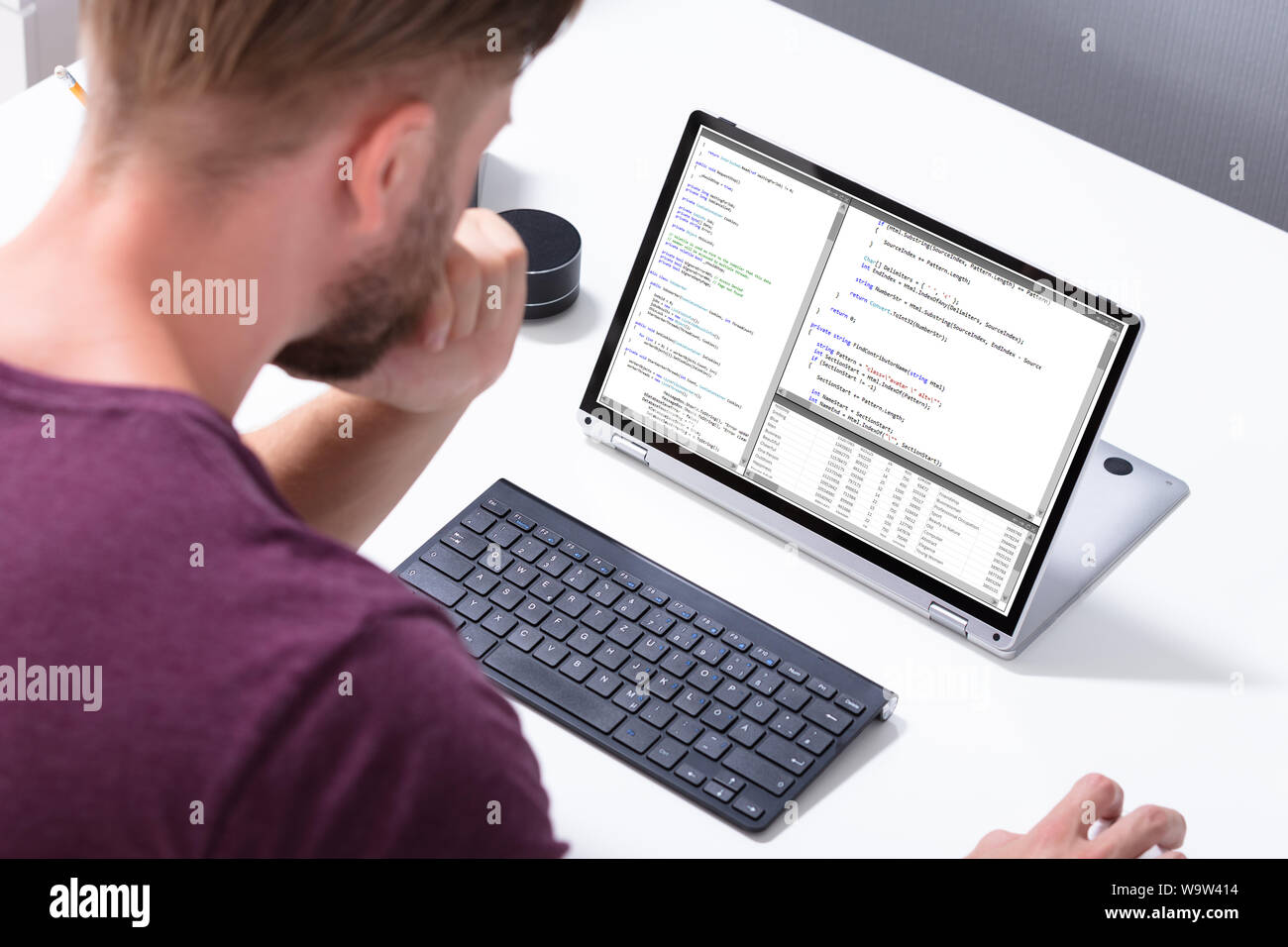 Man Programming Code On Laptop Computer In Office Stock Photo